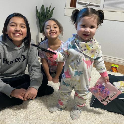 Melia and her sisters sitting together and smiling